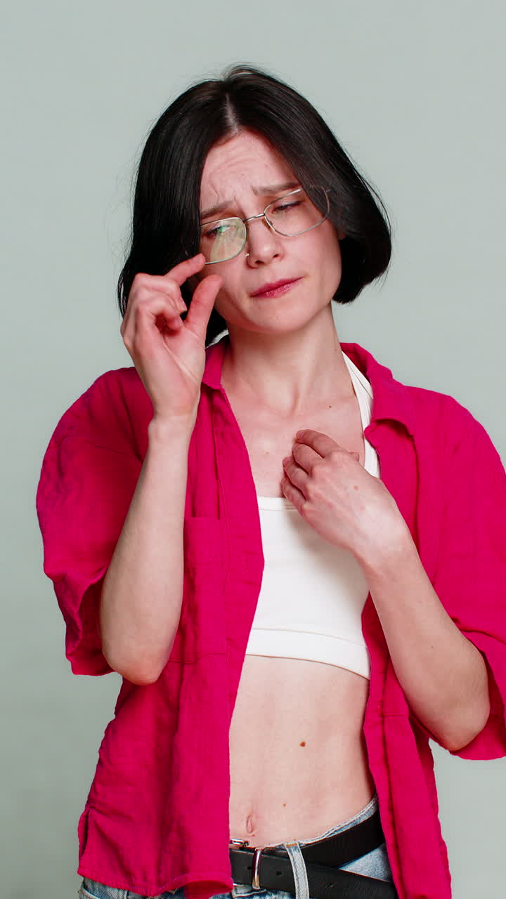 Woman holding hands together pleading with head tilted emotionally begging asking favor gesture