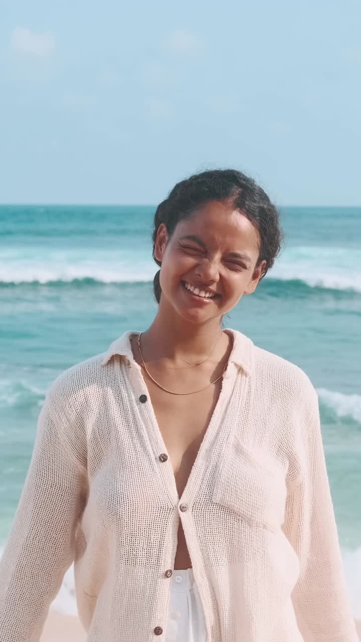 Young couple enjoys a joyful day at the beach with heart gesture