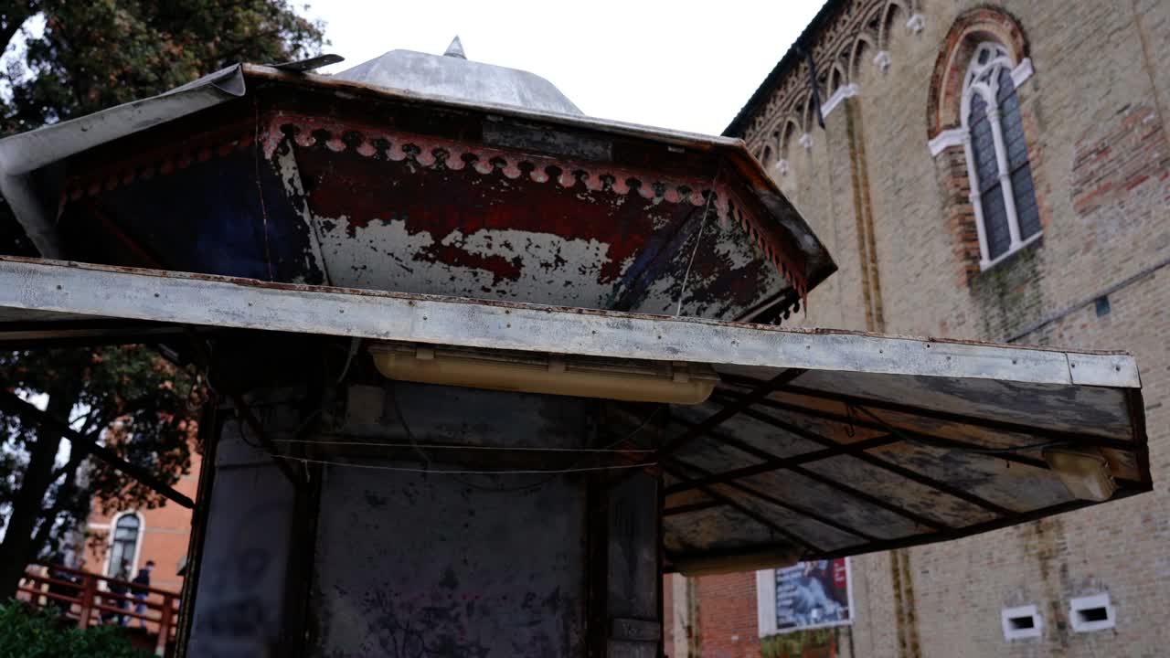 둥근 금속 지붕 을 가진 작은 고대 녹은 신문 상점