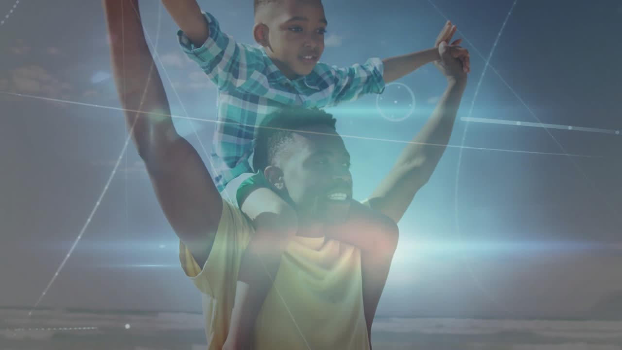 Portando un bambino con abiti scozzesi sulle spalle, padre in giallo che tiene fermo il bambino che gioca, grafica del sole sulla spiaggia che si avvia