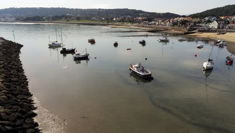 aerial view boats in shimmering low tide sunny warm rhos on sea seaside sand beach rocky jetty orbit left