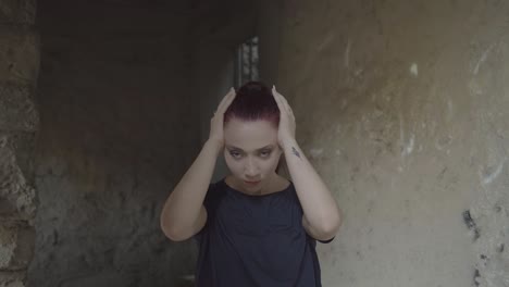 portrait of a woman dramatically holding her head with a theatrical and angry expression in a dark old room