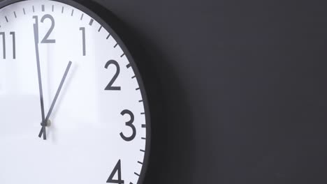 simple clock hanging on black wall close up