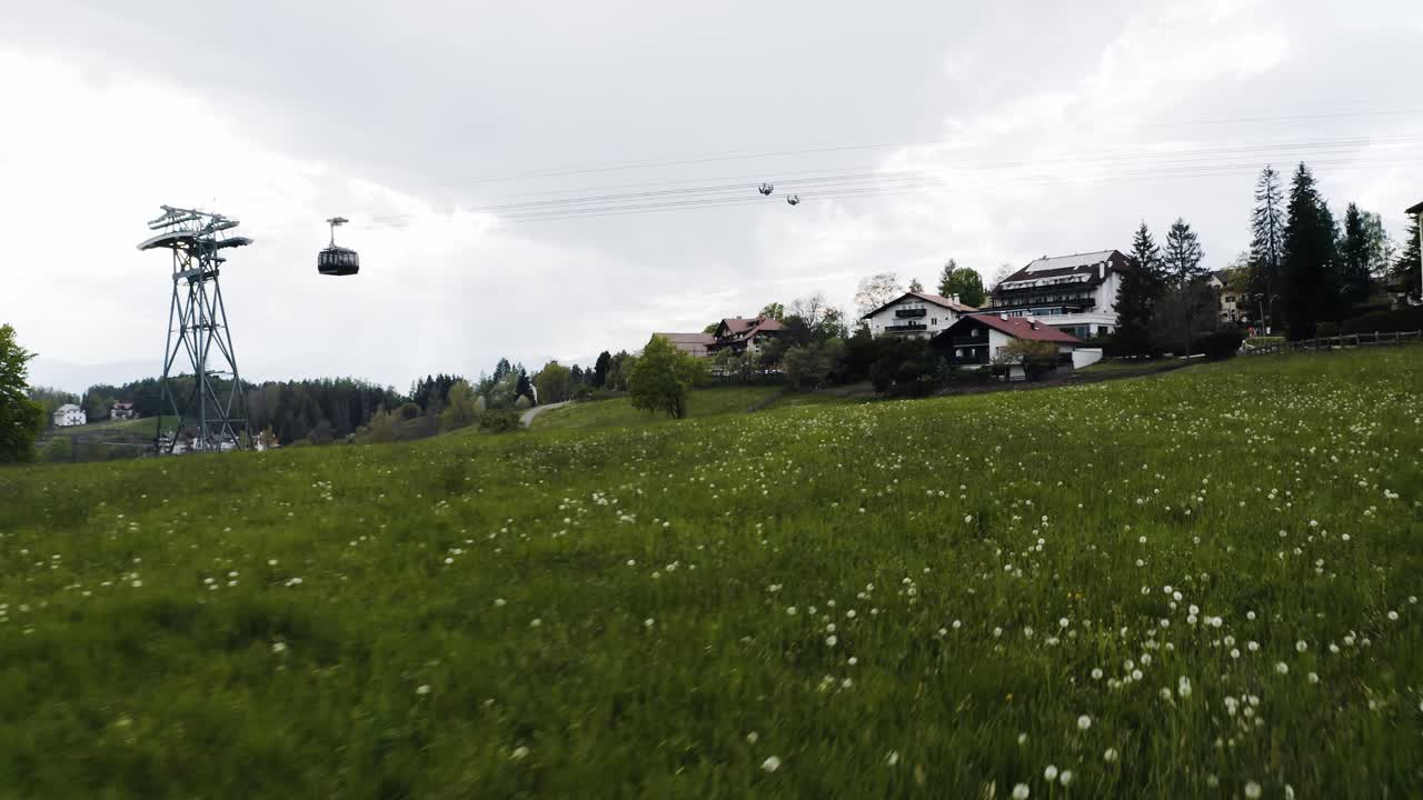 Flying over a field of flowers in Italy's rural countryside with a tram coming into town overhead