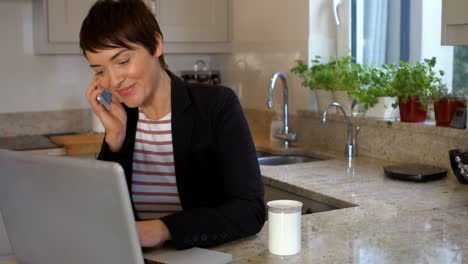 mujer usando portátil y teléfono inteligente