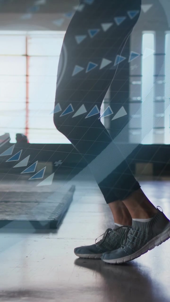 Vertical video: Female exerciser tapping heels then hopping in gym, via UI cues for cardio training