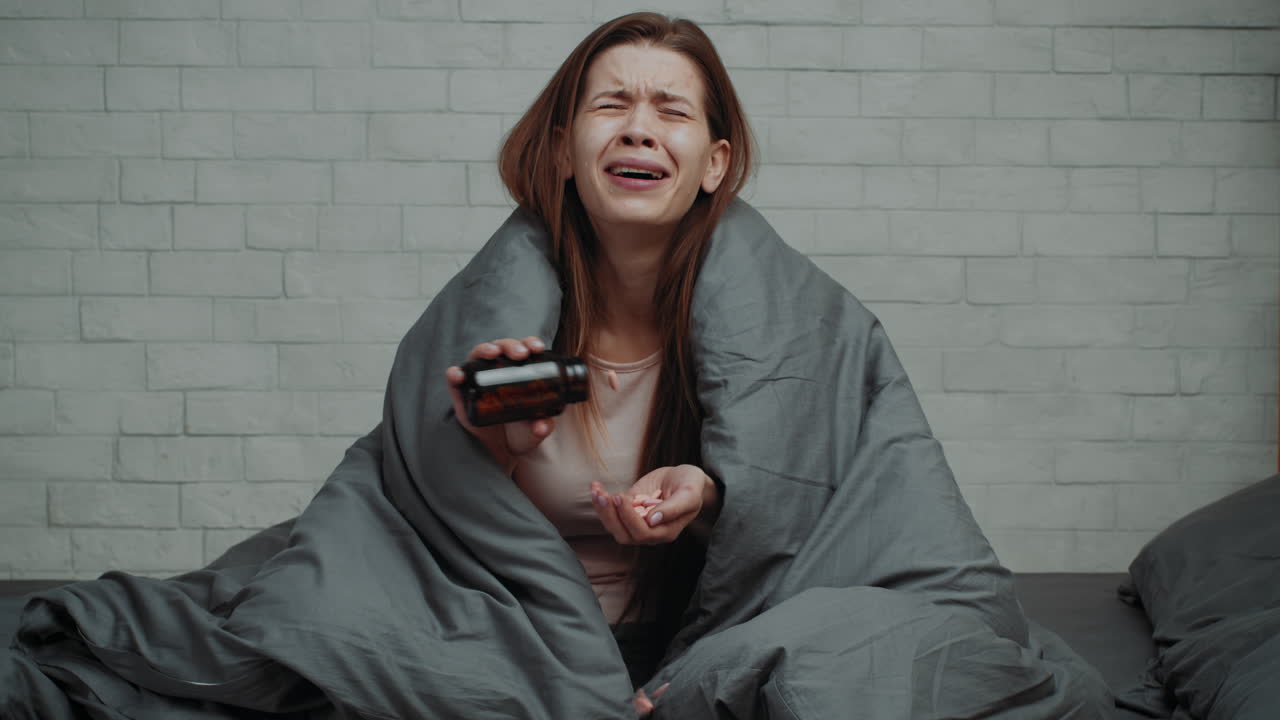 Woman Crying and Taking Medication in Bed