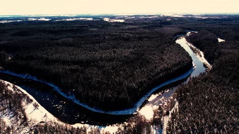 a winding river near a small town with a forest massif