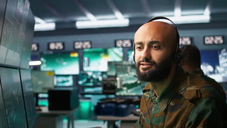 radio communications operator discussing with colleague using headset mic