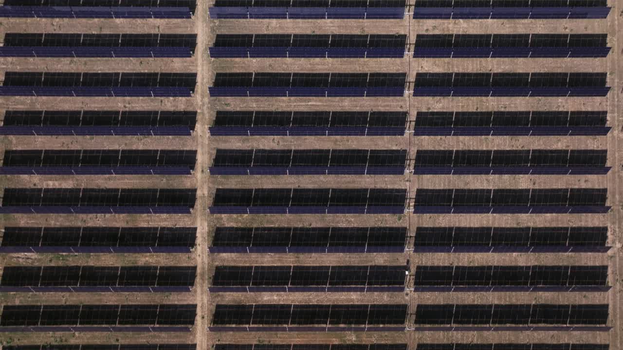 filas de paneles solares en un patrón de cuadrícula en una gran granja solar del desierto vista desde arriba
