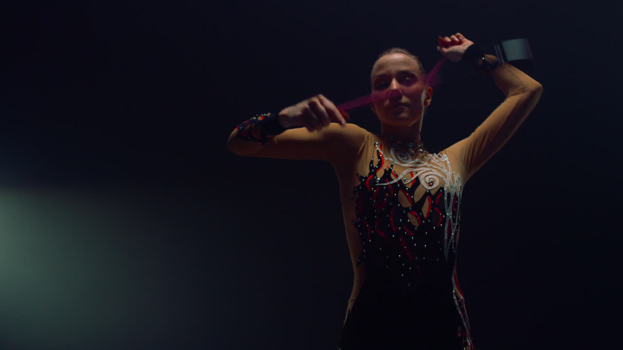 Charming girl doing rhythmic gymnastics. Woman gymnast performing with clubs.