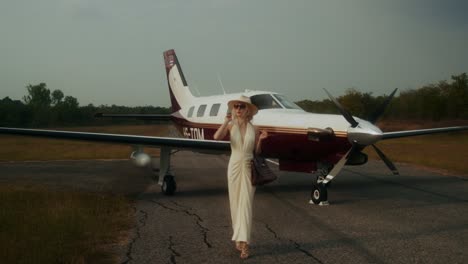 woman walking toward a private jet at an airport.