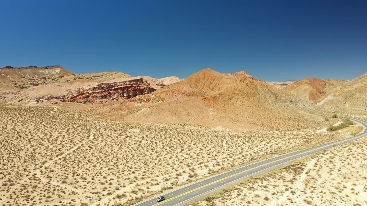 모하비 사막의 울퉁불퉁하고 건조한 풍경을 통과하는 외로운 고속도로 - 하강 조감도