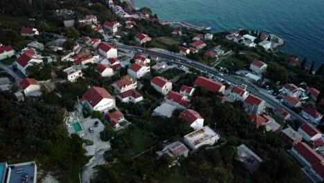 video aéreo 4k de drones del área residencial de mlini que se extiende hacia arriba y hacia los alrededores impresionantes con agua y montañas, croacia
