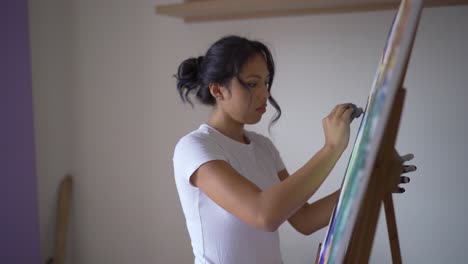 artist with dirty hands painting on canvas