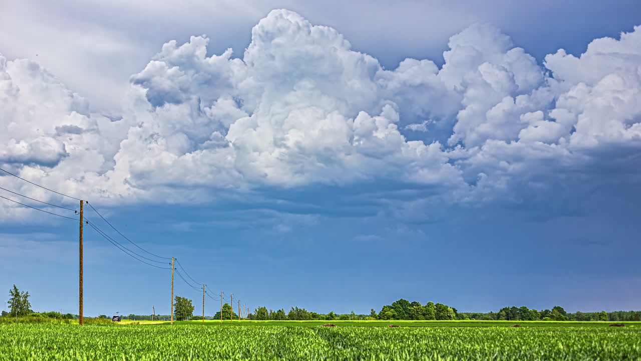 하 구름이 녹색 시골 도로 위에 날아 전기 기둥 시간 지연