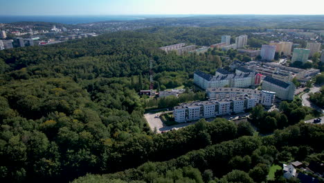 aerial flyover forest landscape and polish neighborhood with apartment blocks in witomino, gdynia city