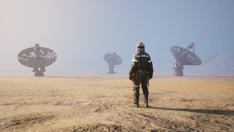 worker observes large satellite dishes in a remote desert area during daylight