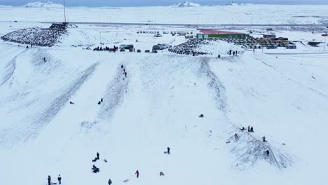 people sliding down kambur tourist attraction in njarðvík, iceland, aerial