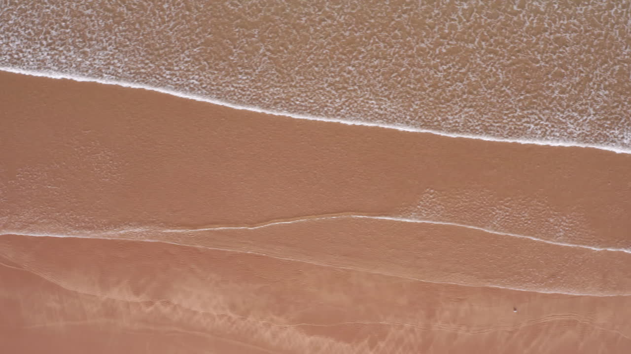 모래 황금 해변에 lapping 파도의 공중 트럭 샷