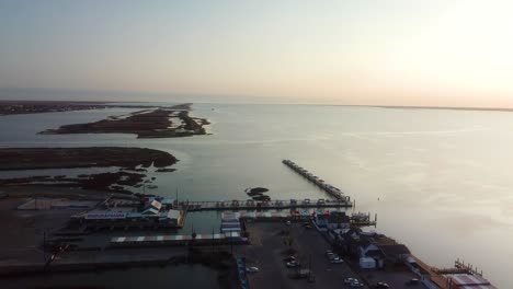 vista aérea estacionaria del puerto deportivo, las islas y el canal intercostero del golfo en laguna madre entre la isla del padre norte y corpus christi texas al atardecer