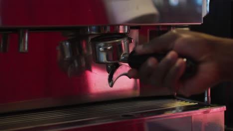 Mittelteil-Eines-Afroamerikanischen-Männlichen-Barista,-Der-Kaffee-In-Der-Kaffeemaschine-Zubereitet