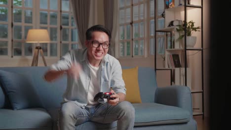 man gamer very happy with his success, playing game in the modern room, hand gesture
