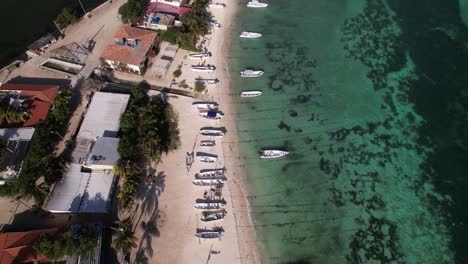 Vista-Aérea-De-Arriba-Hacia-Abajo-De-La-Playa,-Inclinada-Hacia-Arriba-Para-Revelar-El-Aeropuerto-De-Los-Roques,-Isla-Costera-Del-Caribe