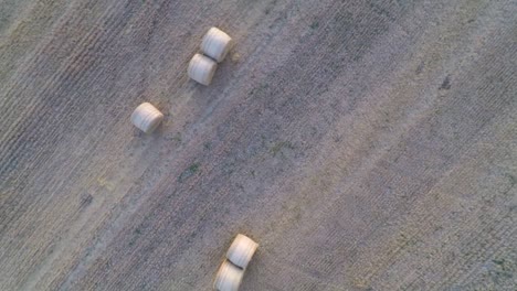 Langsam-In-Einer-Spirale-Vom-Ackerland-Wegfliegen,-Um-Weitere-Wogende-Felder-Und-Heuballen-Zu-Enthüllen