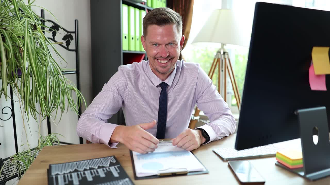 Businessman offering a handshake at his desk