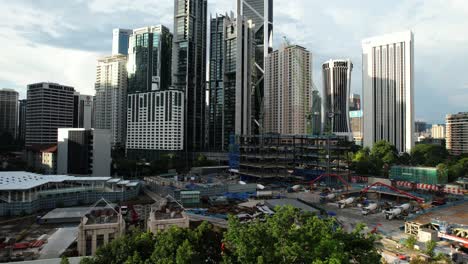 drone aéreo con vistas a una zona de construcción industrial en el centro de kuala lumpur malasia en un día soleado cuando el sol comienza a ponerse con vistas al gran horizonte y muchos rascacielos