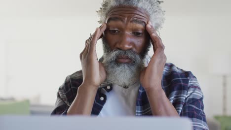 stressed man massaging his temples at home