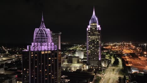 Wide-view-of-downtown-Mobile,-Alabama-at-night-with-drone-video-moving-right-to-left