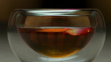 té de rosas en una taza de vidrio de doble pared