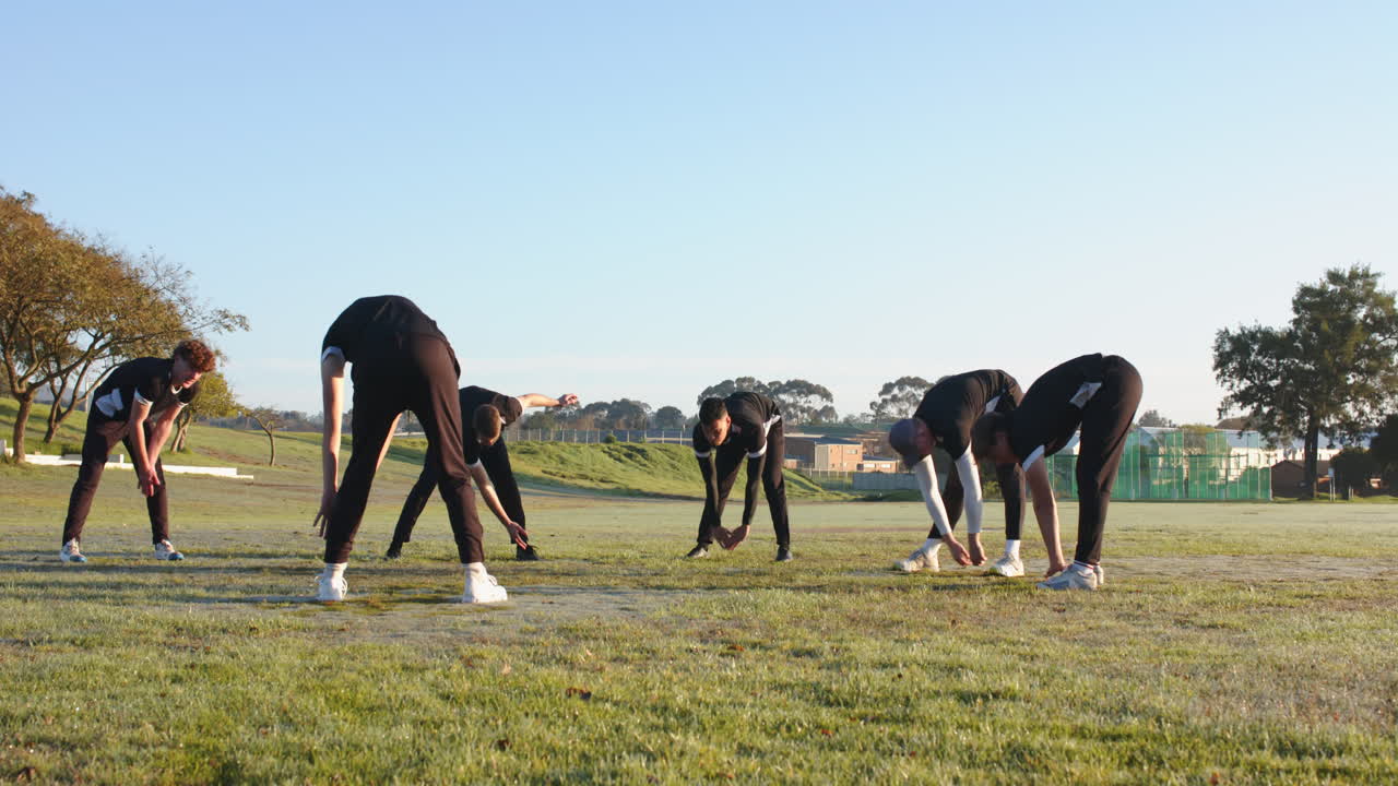 Cricket players stretching on field, preparing for practice session outdoors
