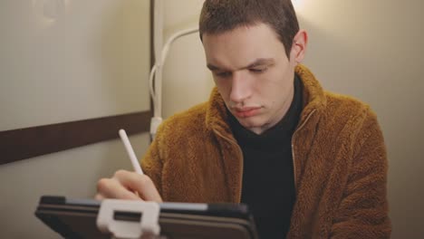 caucasian man writing on tablet using stylus pen - medium shot