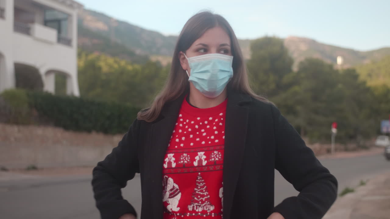 Joven adulto poniéndose una mascarilla quirúrgica en la calle y mirando a su alrededor.