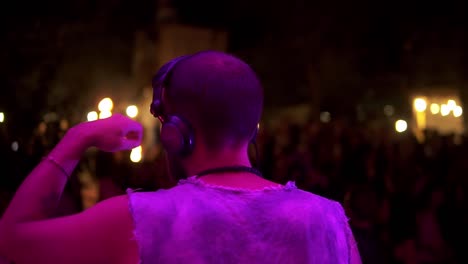 dj masculino en un estado de ánimo relajado agitando la mano al ritmo de la música, la gente está bailando por la noche teniendo una fiesta al aire libre