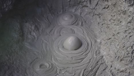 boiling hot geothermal volcanic mud pool, closeup shot steamy lake bubbling mud and steam satisfying