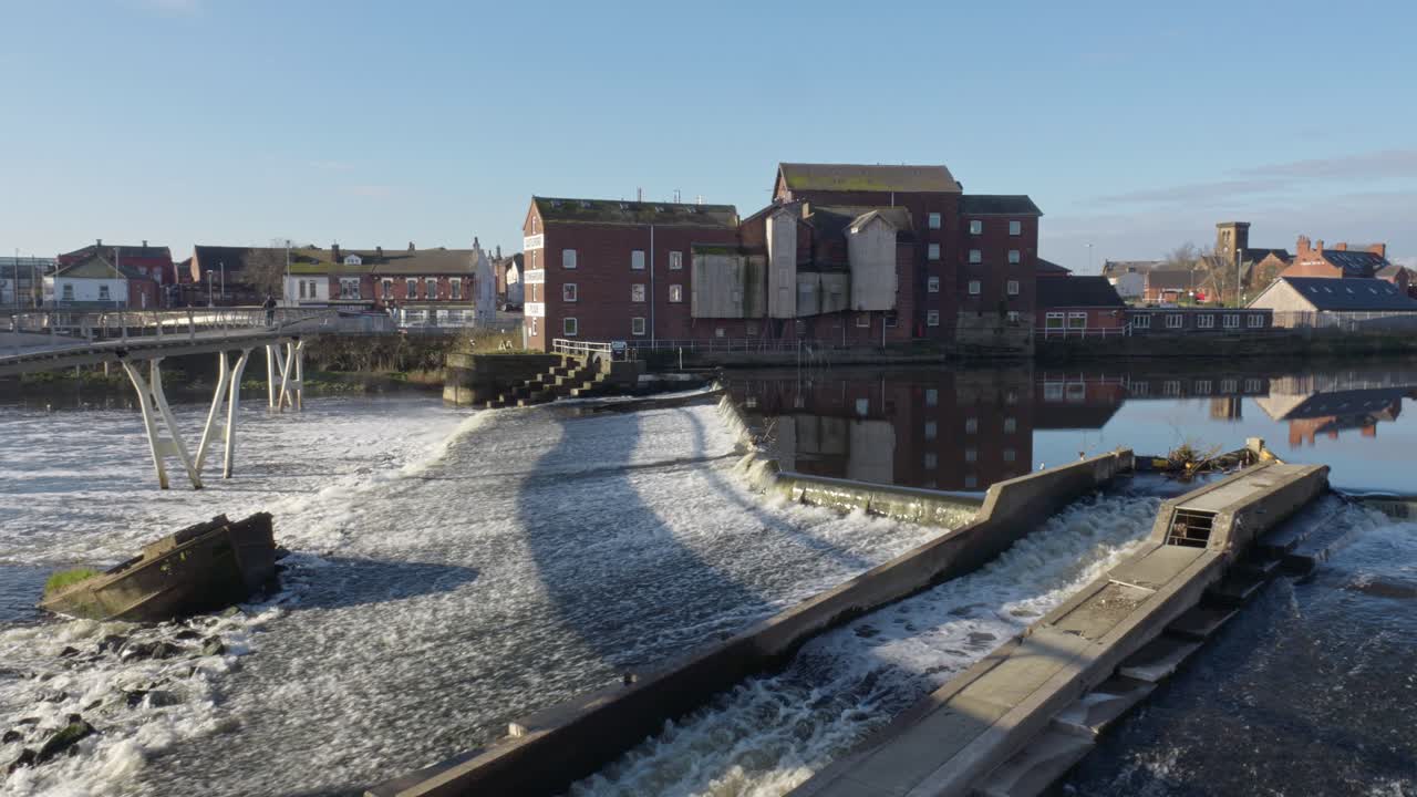 castleford weir mostrando el antiguo molino harinero en funcionamiento en la orilla del río aire yorkshire, reino unido en un brillante y soleado día de primavera