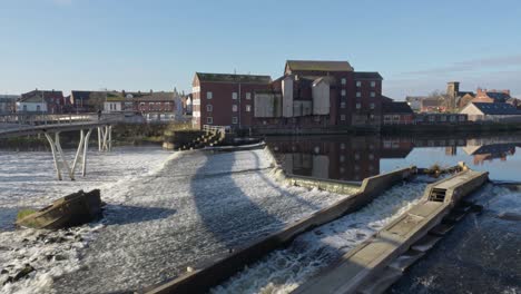 castleford stuw met oude werkende korenmolen aan de oever van de rivier de aire yorkshire uk op een zonnige lentedag