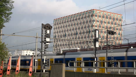 train crossing in gouda train station and the building of city hall in amsterdam, netherlands