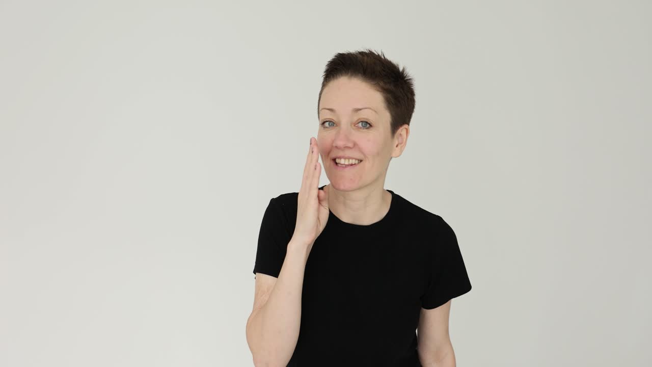 A woman with short hair making a hand gesture