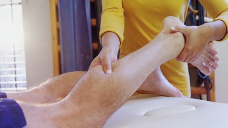 fisioterapeuta dando masaje de piernas a un hombre 4k