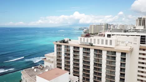 hawaii aerial drone view flying close over top of hotel rooftop with honolulu waikiki beach in view