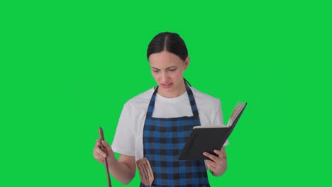 ama de casa india confundida haciendo comida del libro de recetas pantalla verde
