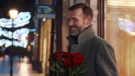 mature man buying red roses in a flower shop