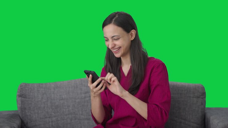 mujer india feliz usando la pantalla verde del teléfono