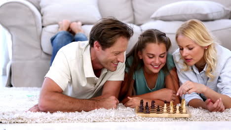 parents and daughter playing chess