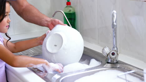 Close-up-father-and-daughter-doing-the-dishes-